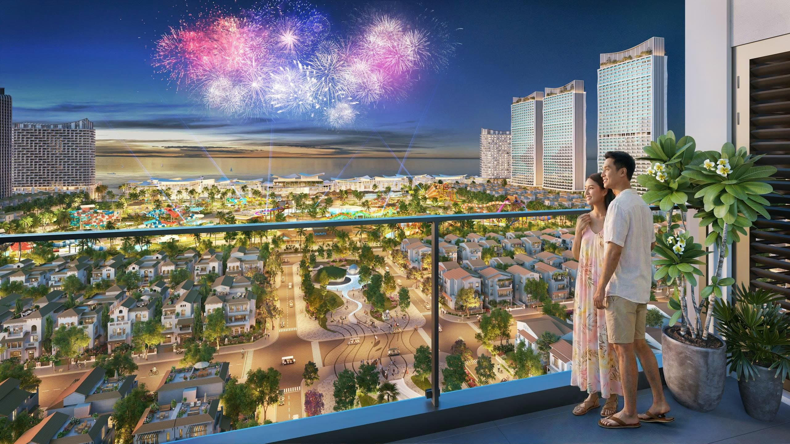 Nhìn từ ban công một căn hộ Beacon về đêm: khu thấp tầng và quảng trường lên đèn phía dưới, công viên nước và dải nhà hàng mặt biển ở giữa, cụm tháp căn hộ bên phải, pháo hoa trên nền biển lúc chạng vạng