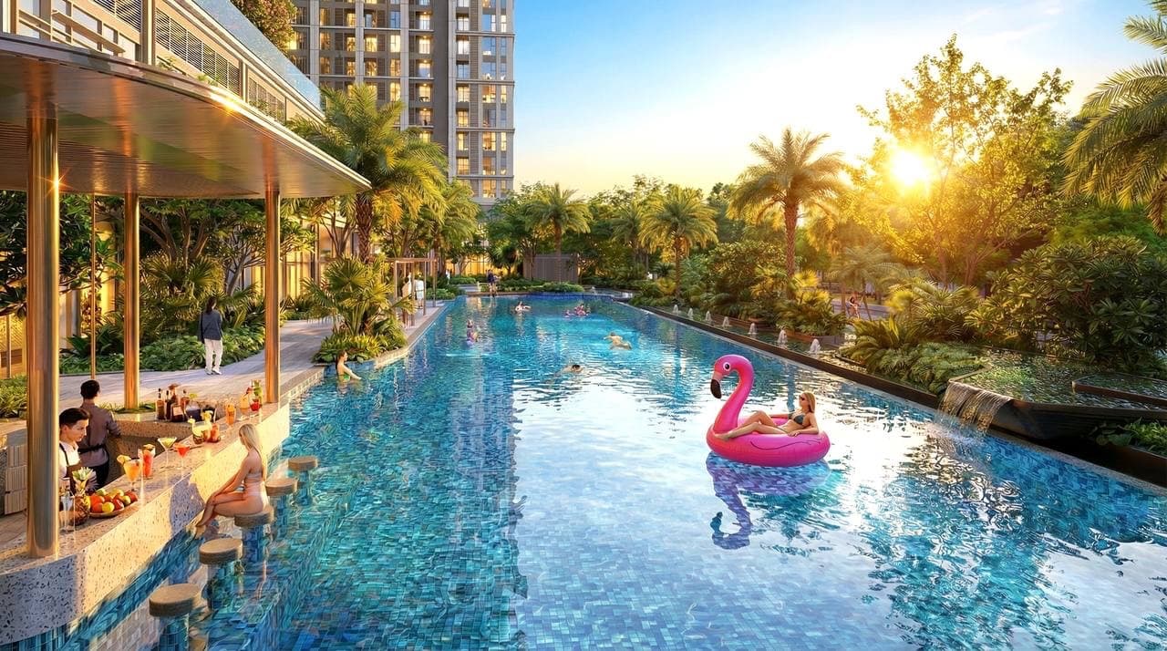 Bể bơi lagoon xanh biếc với quầy pool bar, phao hồng, hàng dừa và tòa căn hộ phía sau