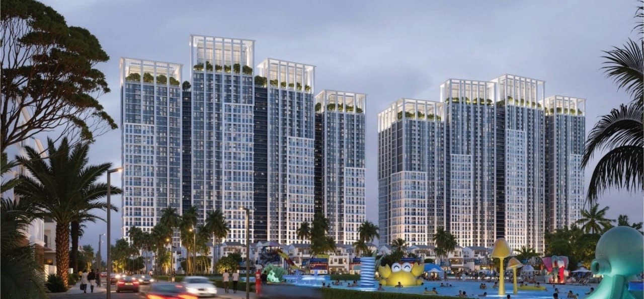 Cụm tháp căn hộ cao tầng lúc chạng vạng, phía trước là bể bơi trẻ em và đường nội khu