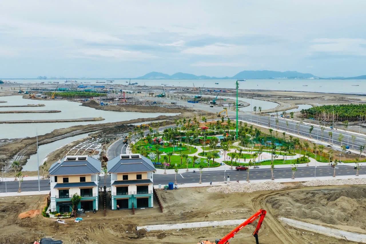 Ảnh chụp từ trên cao các căn nhà mẫu và công viên đã hoàn thiện giữa khu vực đang thi công hạ tầng